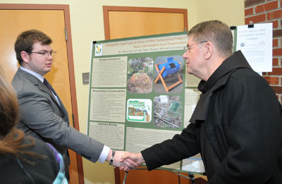 Matt Porter '15 shakes hands with Siena President Br. F. Edward Coughlin,O.F.M., Ph.D. after presenting his group's award-winning sustainability project.