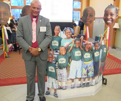 Esperandieu Cenat stands with cutouts of children from the St. Francis Xavier Haitian Orphanage during the annual 